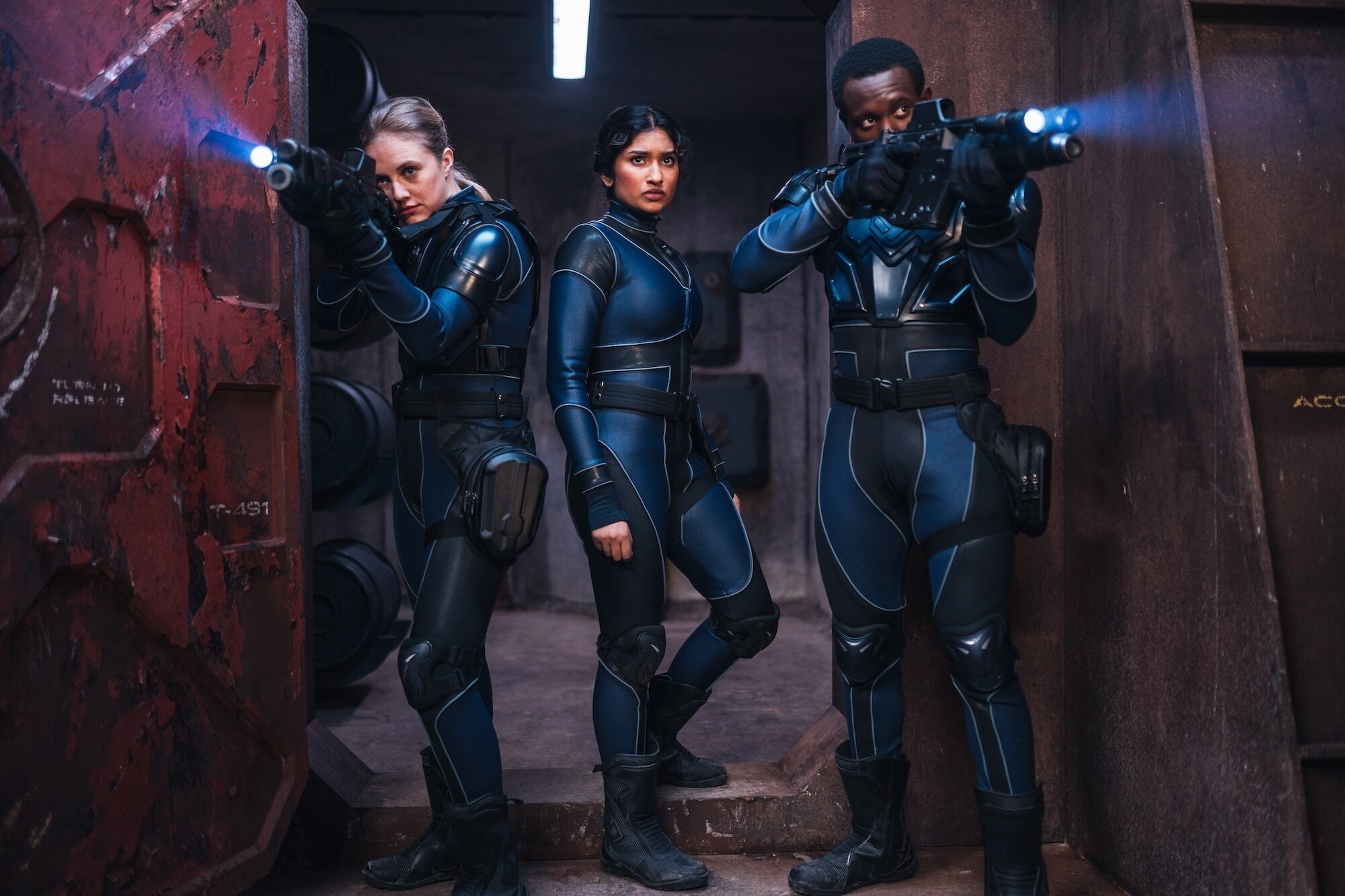 Belinda and two soldiers in a door way seemingly looking for something.