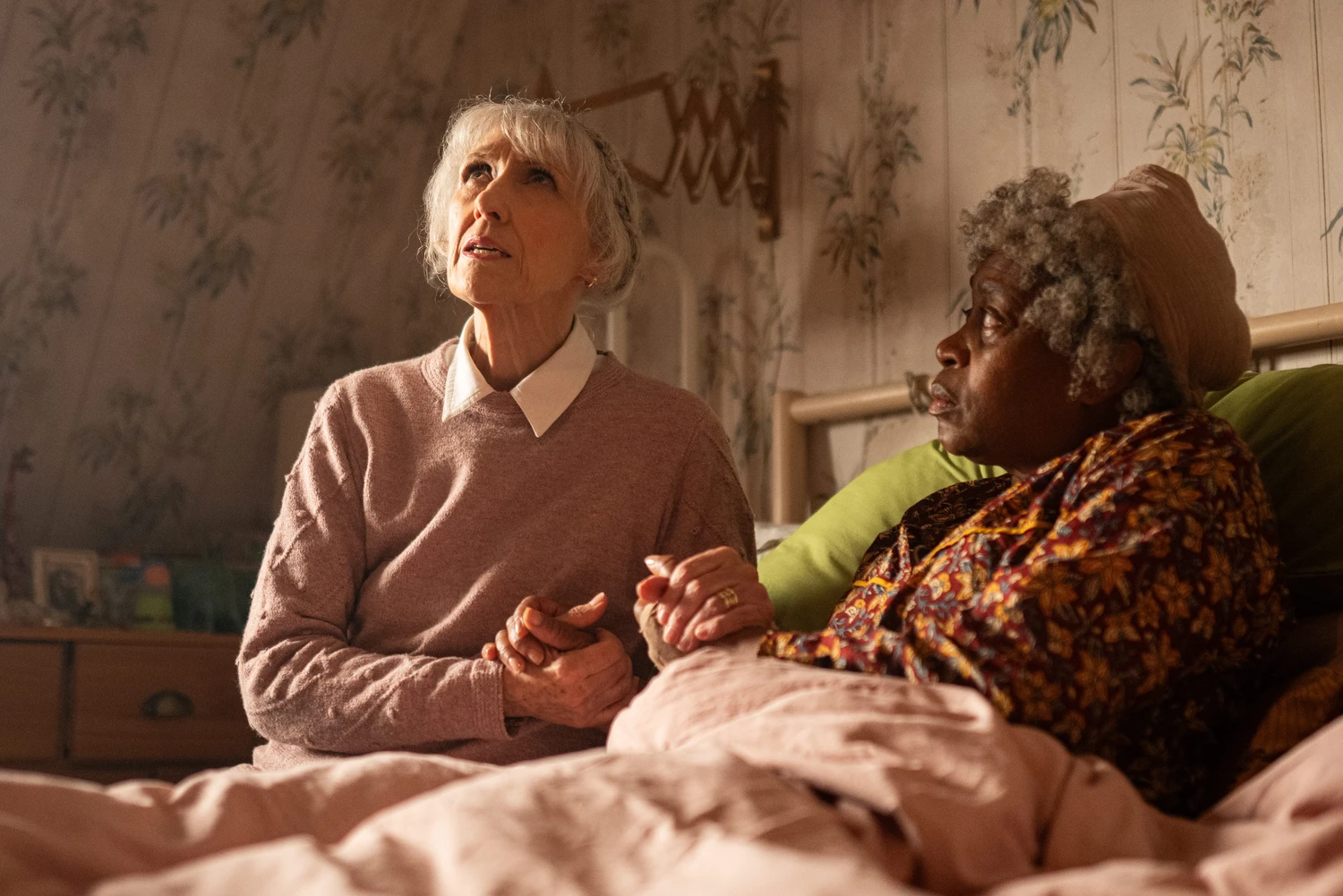 Miss. Flood (Antia Dobson) and Cherry Sunday (Angela Wynter) comfort each other scared of something unseen.